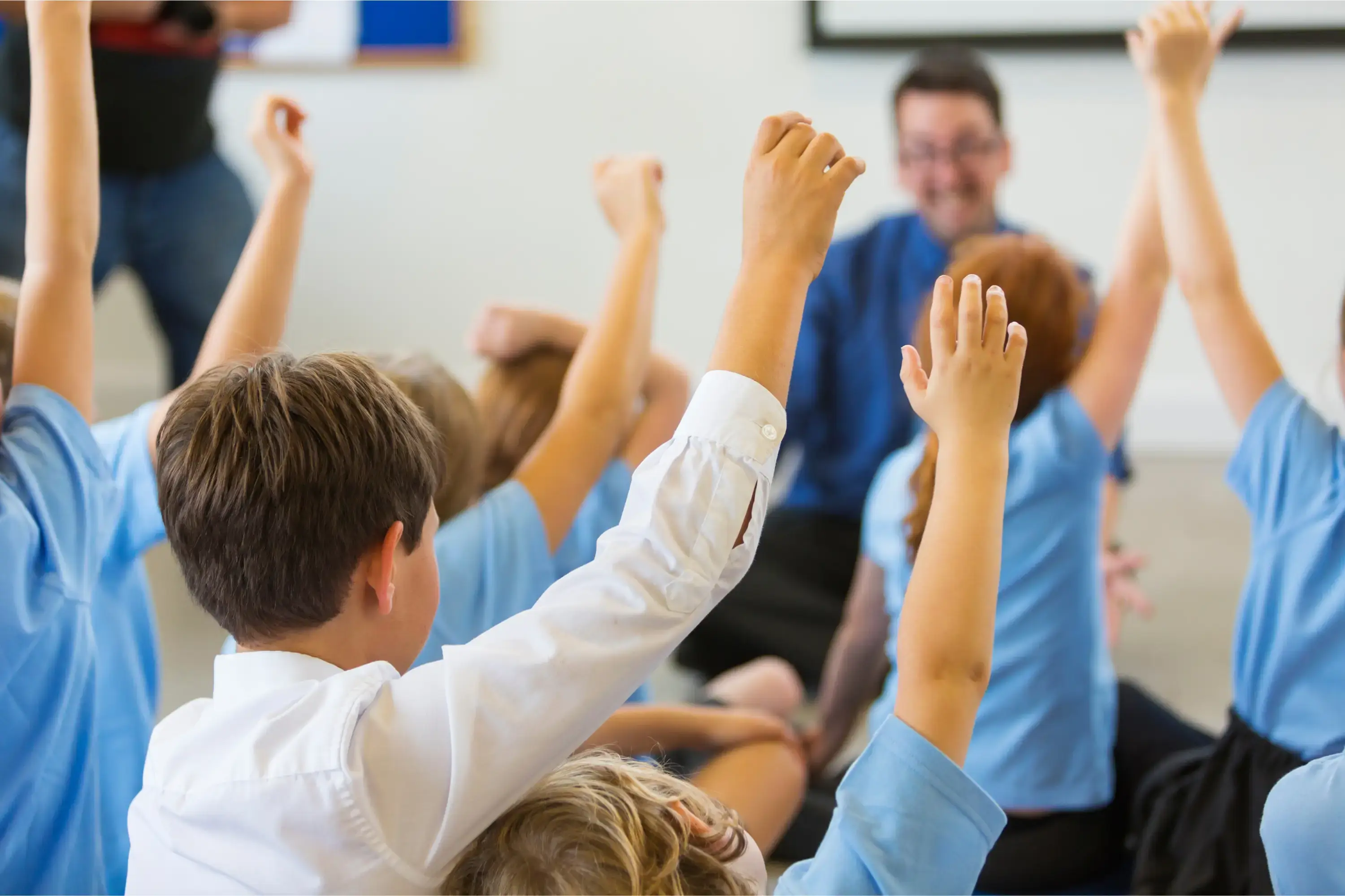 children-raising-hands-in-class